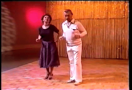 A GIF of a man and woman from around 1050's awkwardly dancing